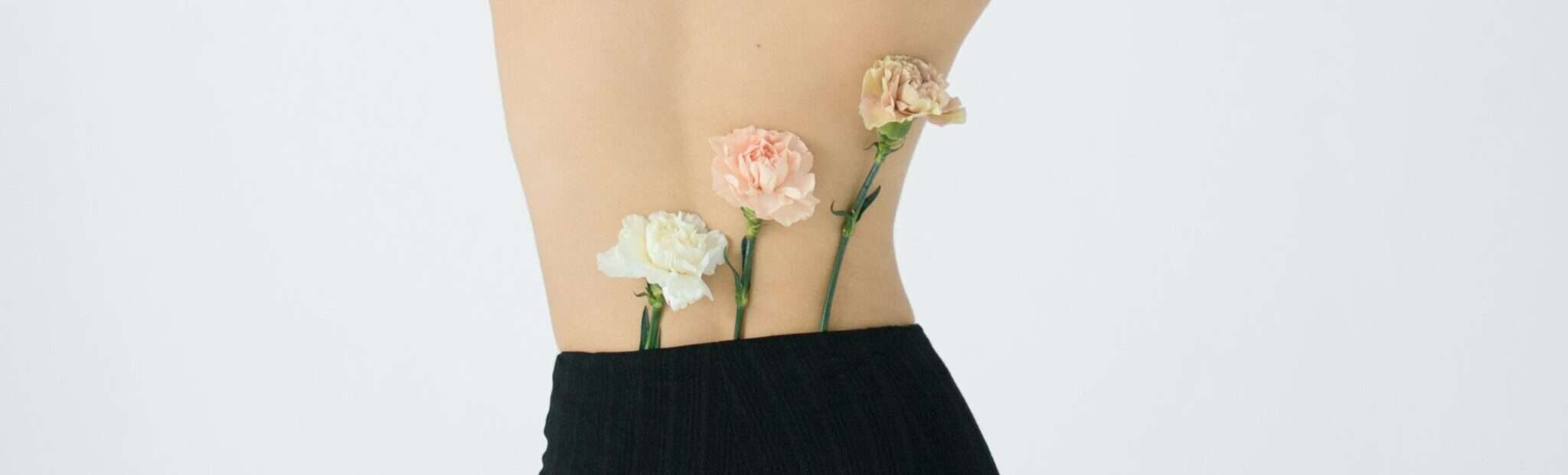 Depilacion laser en lumbosacra, mujer de espaldas con flores