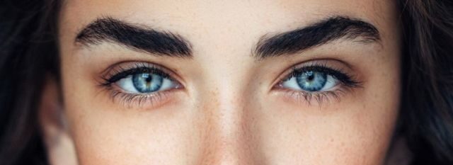 Mujer con cejas pobladas y ojos azules mirando a la cámara
